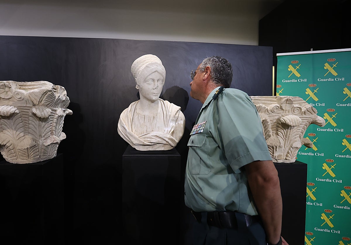 Un miembro de la Guardia Civil junto a una de las piezas más valiosas intervenidas en Baena (Córdoba)