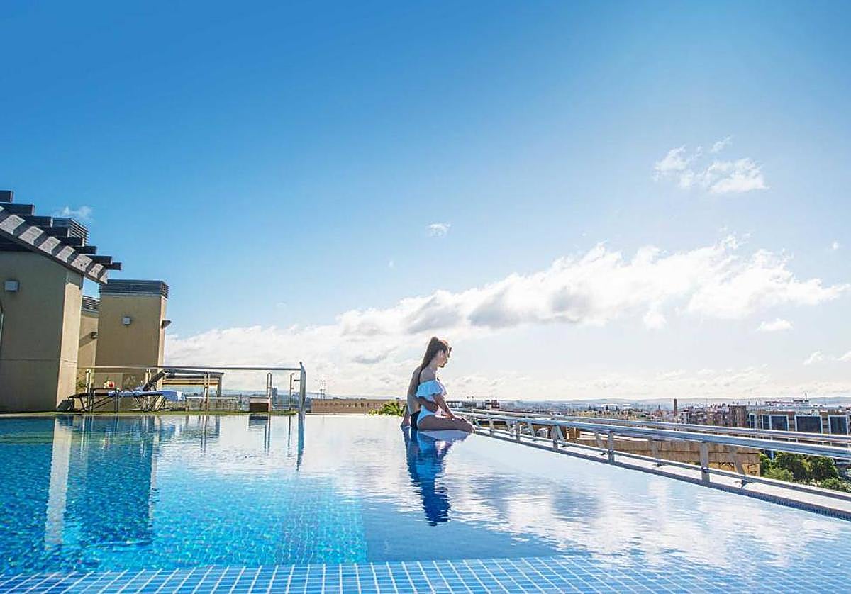 Una pareja se relaja con las vistas desde la piscina del hotel Córdoba Center