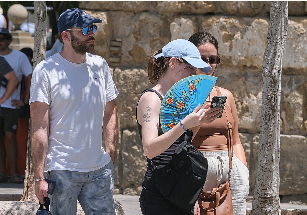 Una mujer se abanica durante un caluroso día sevillano