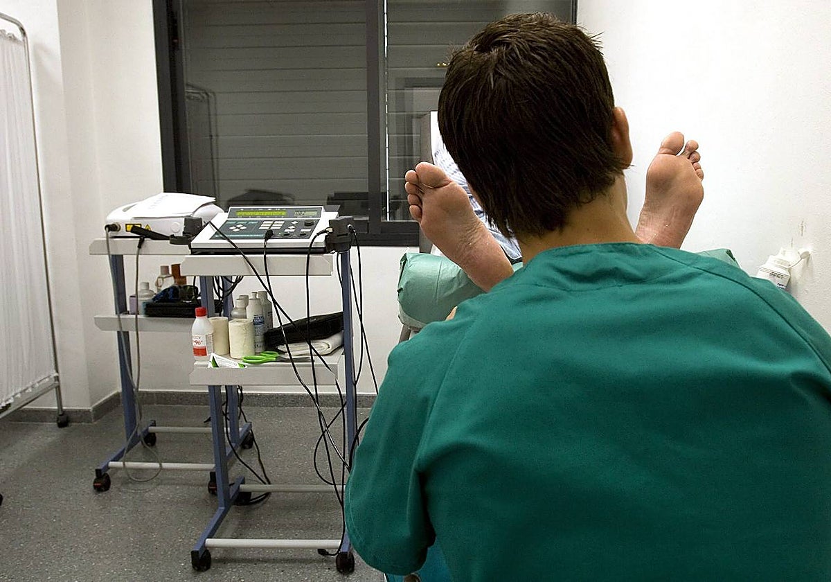 Imagen de archivo de un podólogo tratando a su paciente