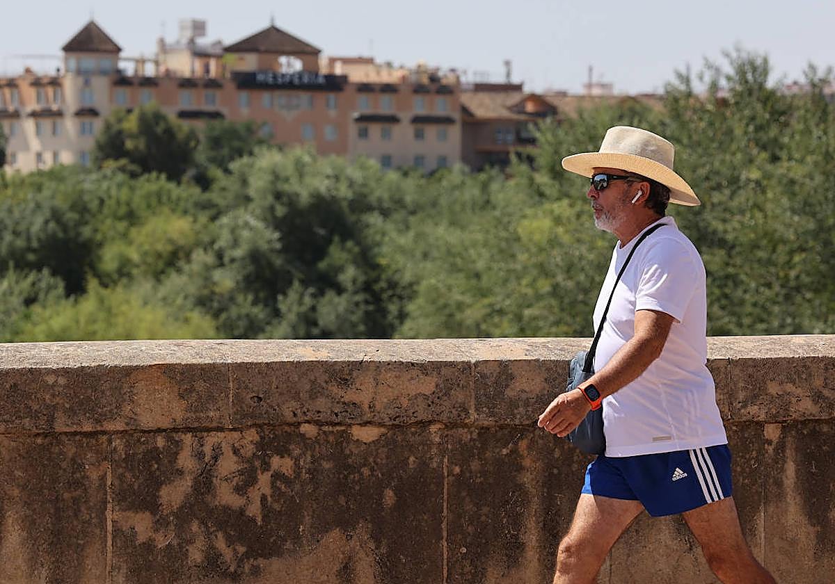 Un hombre pasea por la Ribera, protegido del sol con un sombrero, durante esta ola de calor