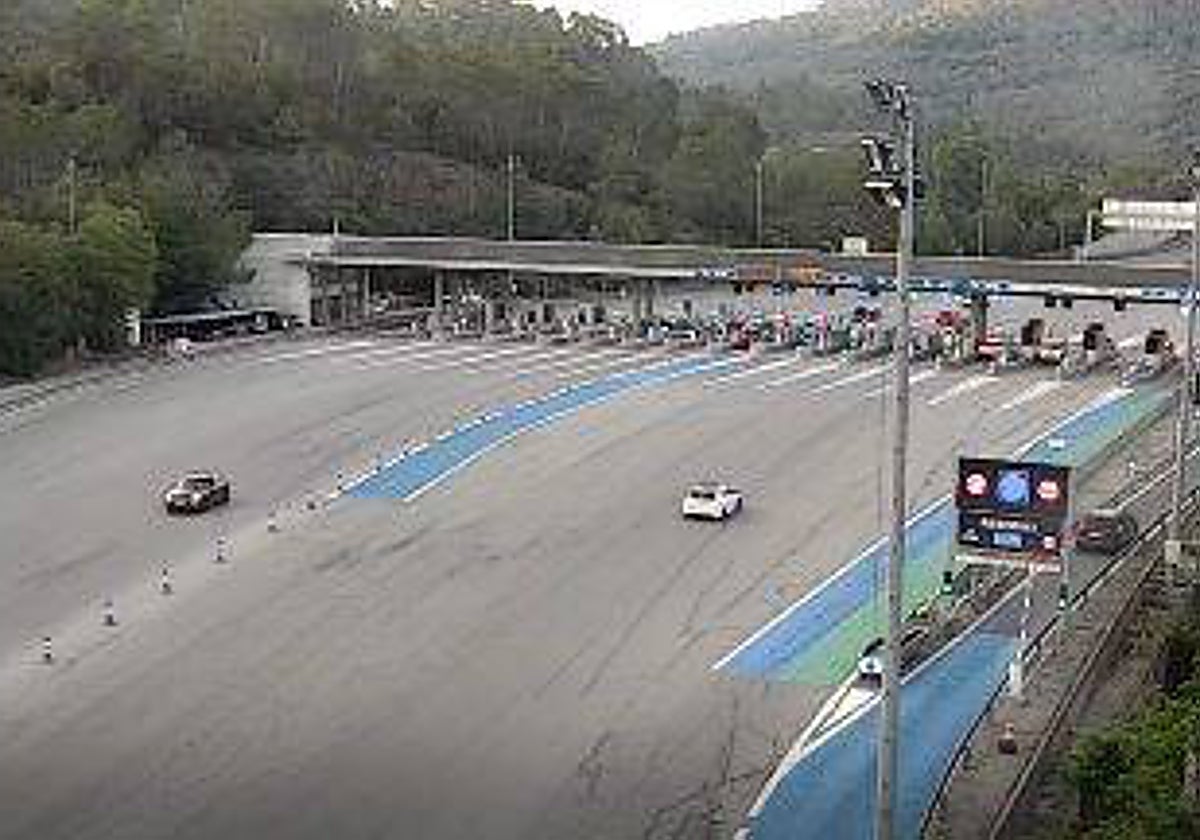 El coche blanco, en el centro de la imagen, llegando a toda velocidad al peaje para colarse