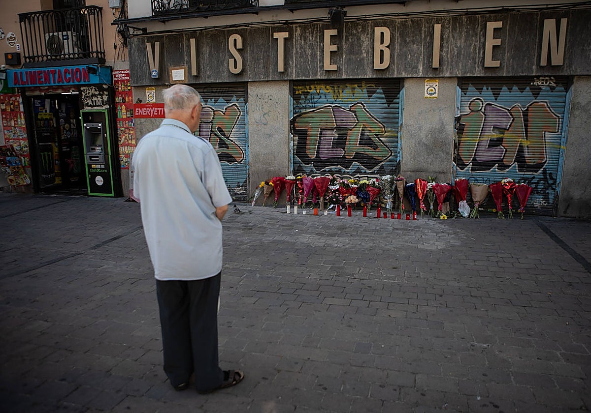 Un hombre contempla el altar de flores que los vecinos han instalado para homenajear a Concha, en Tirso de Molina