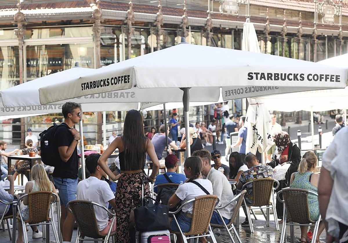 Visitantes con malestas en una terraza junto al Mercado de San Miguel