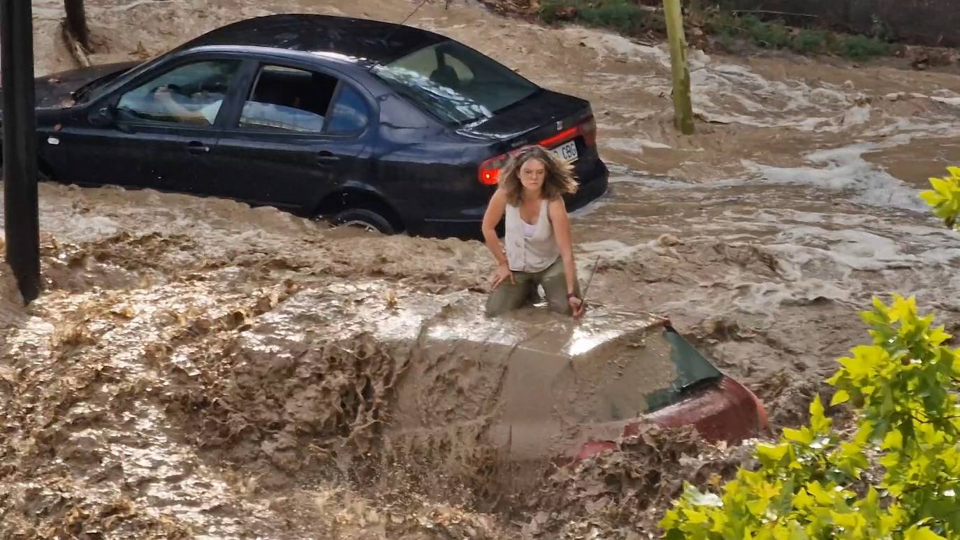 Una mujer se refugia en el techo de un coche 