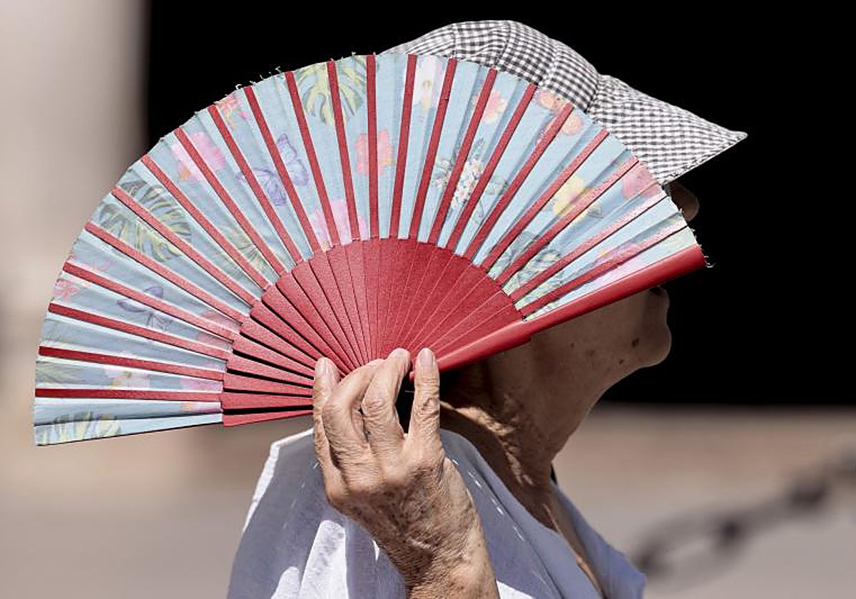 Imagen de archivo de una mujer con un abanico en un día de calor en Valencia