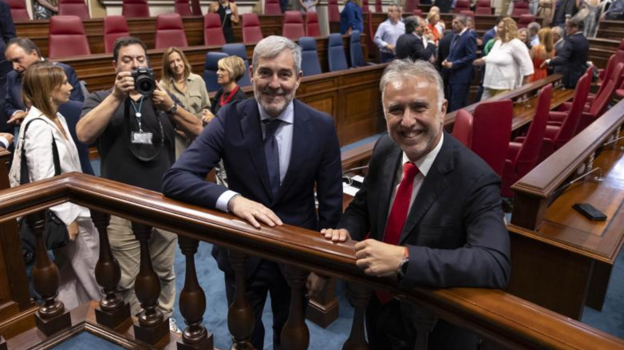 El nuevo presidente de Canarias, Fernando Clavijo (i), de CC, posa con su antecesor, Ángel Víctor Torres (d), del PSOE, tras su investidura.