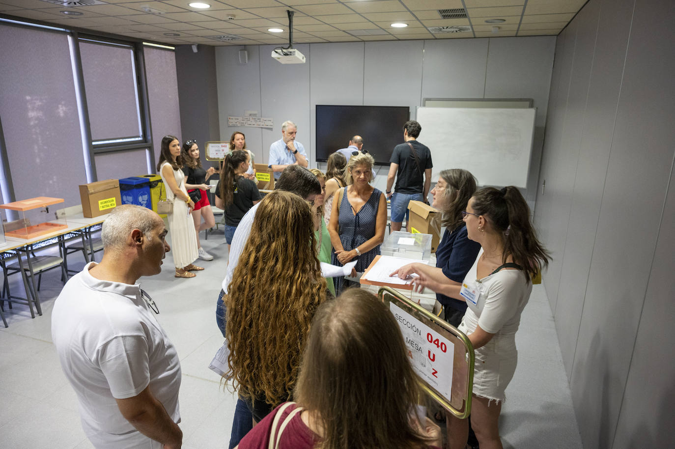 Varios ciudadanos congregados tras ser llamados para formar parte de las mesas electorales antes de la apertura de las urnas en el colegio electoral montado en el Instituto Ortega y Gasset de Madrid