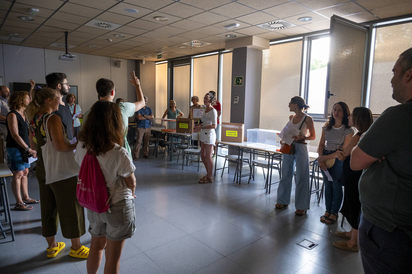 Ciudadanos congregados tras ser llamados para formar parte de las mesas electorales antes de la apertura de las urnas en el colegio electoral montado en el Instituto Ortega y Gasset de Madrid