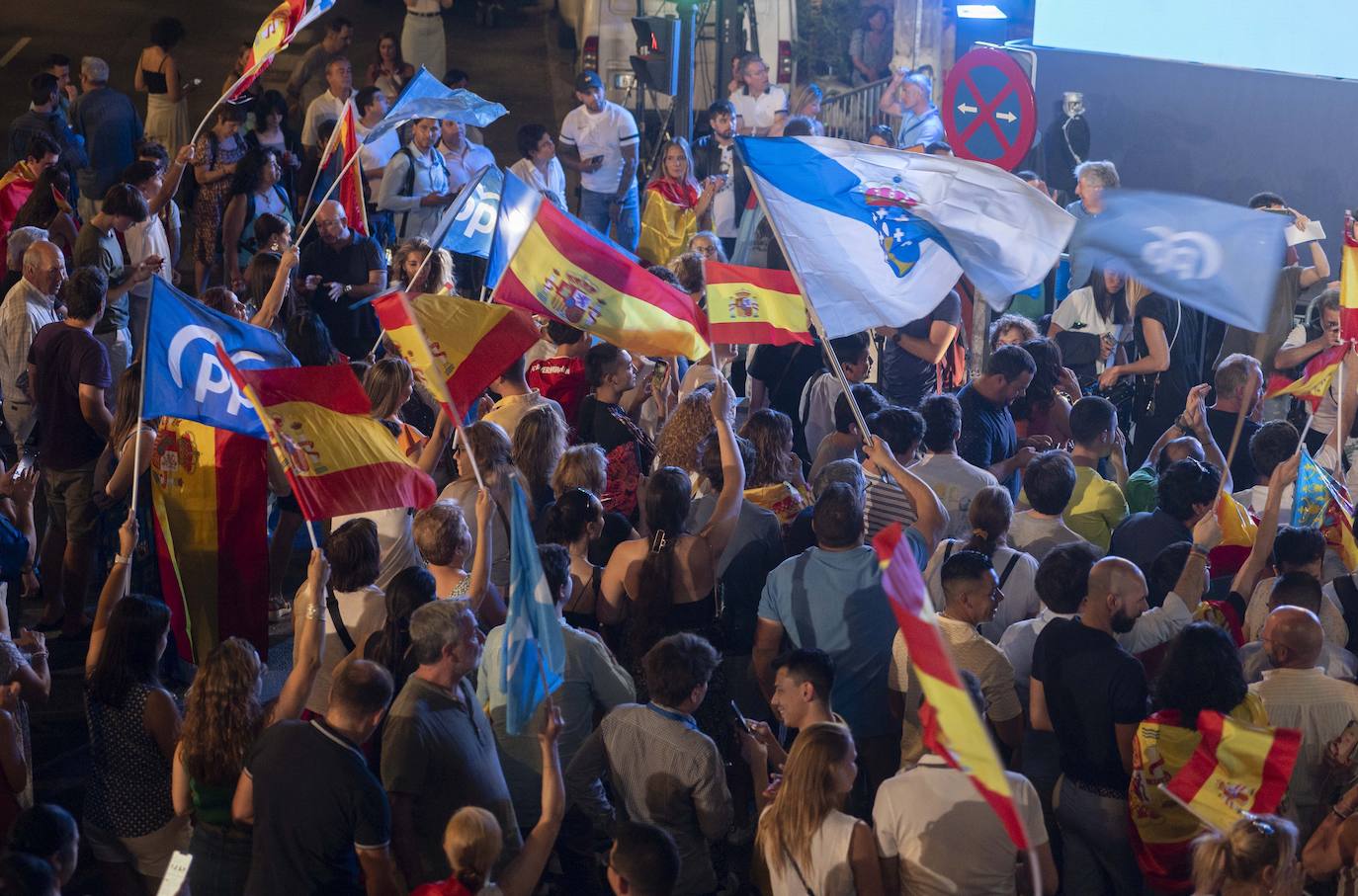 La sede del Partido Popular se llena de simpatizantes y sostienen las banderas de España junto a la del PP