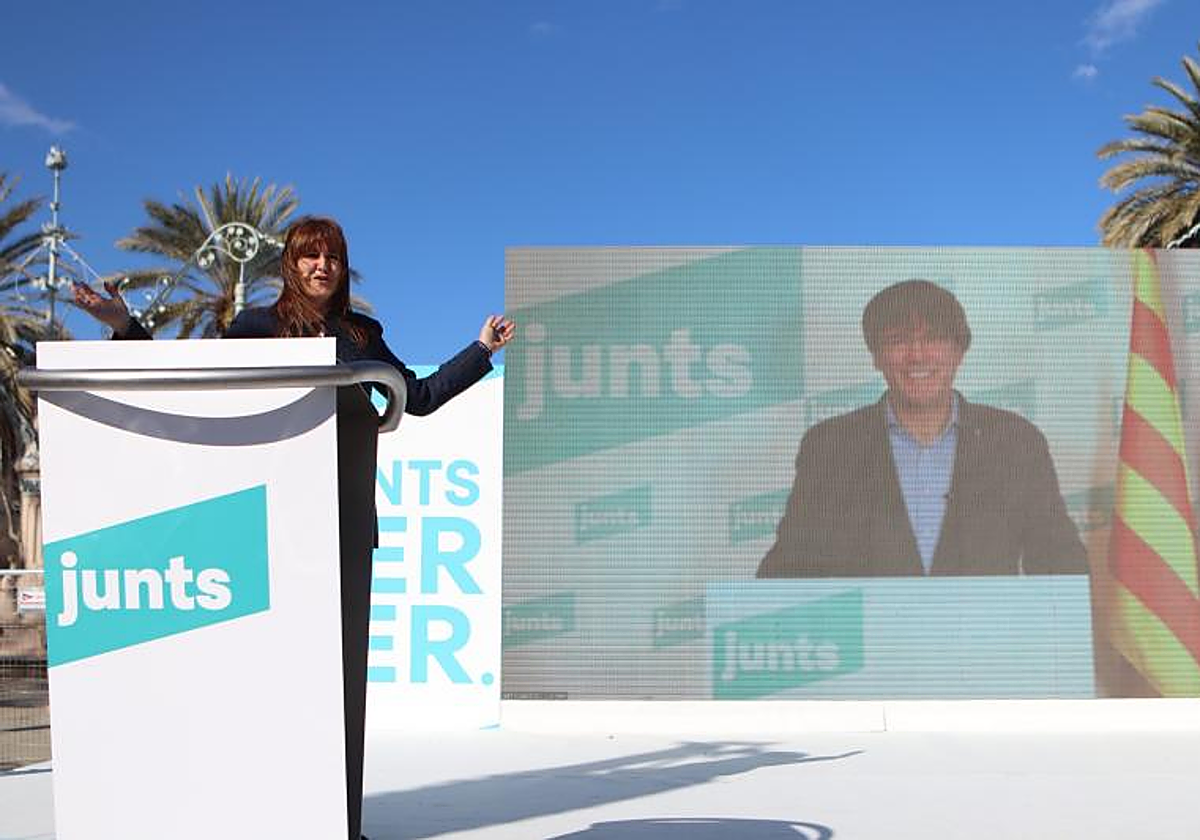 Laura Borràs y Carles Puigdemont, en la pantalla, durante un mitin de Junts en Barcelona celebrado en 2021