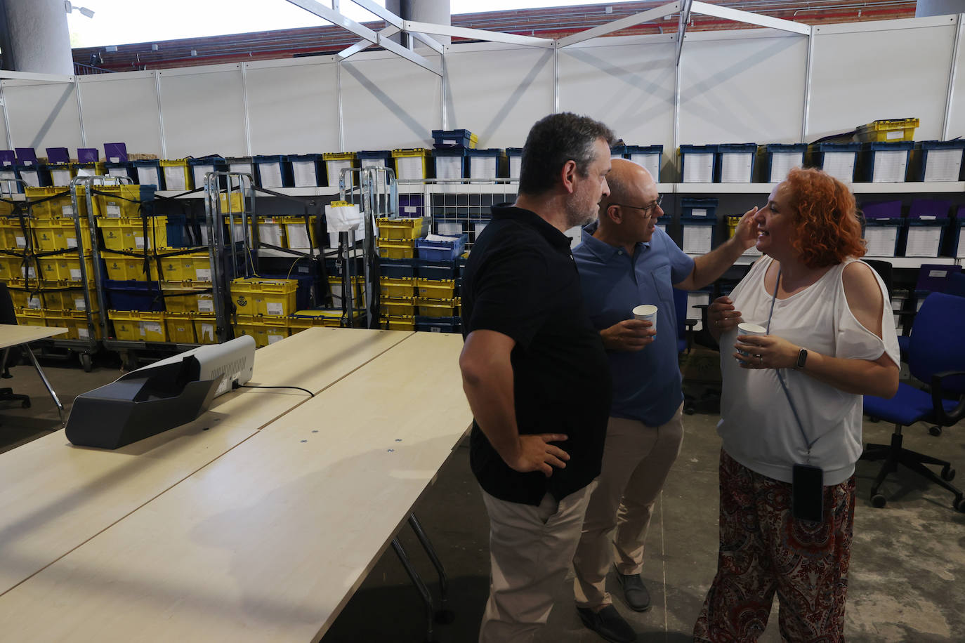 Varios funcionarios junto a las cajas donde se albergan los votos emitidos en el exterior