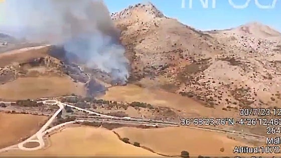 Los bomberos tratan de apagar un incendio forestal en Antequera