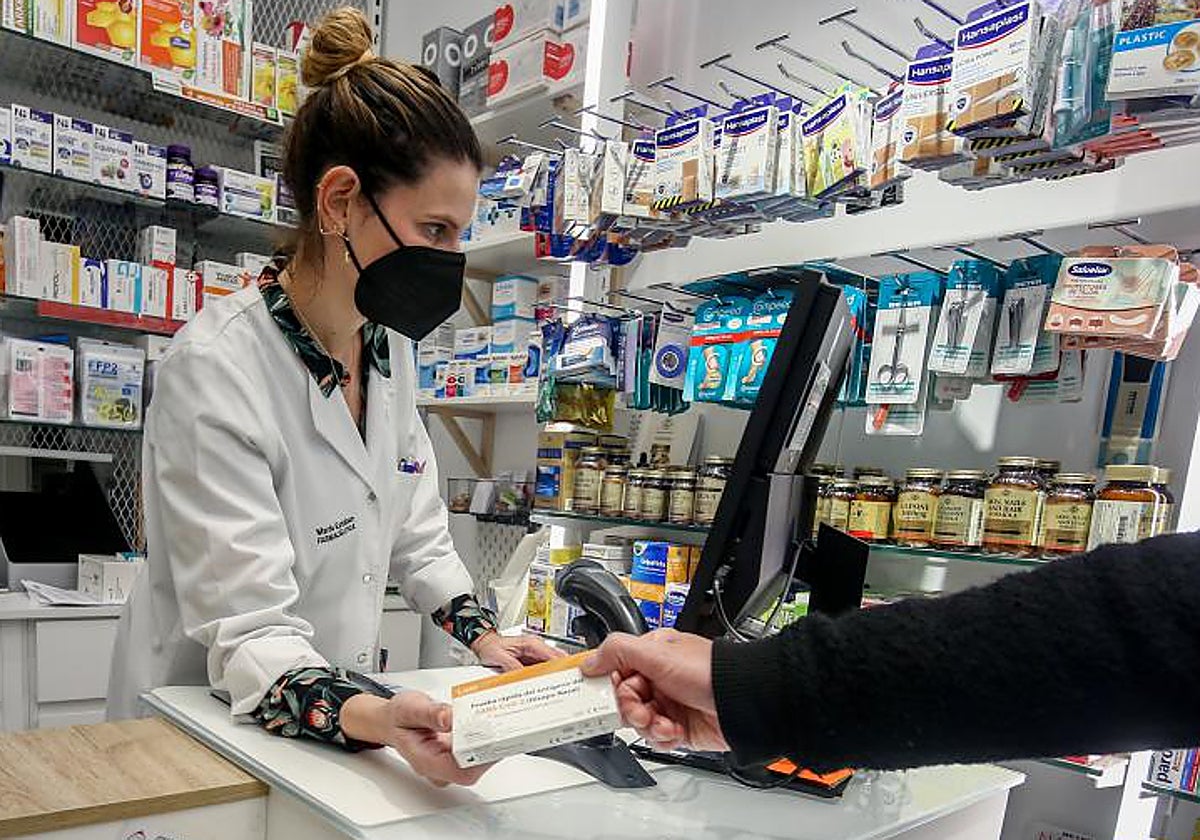 Una farmacéutica entrega un producto a un cliente, en Madrid
