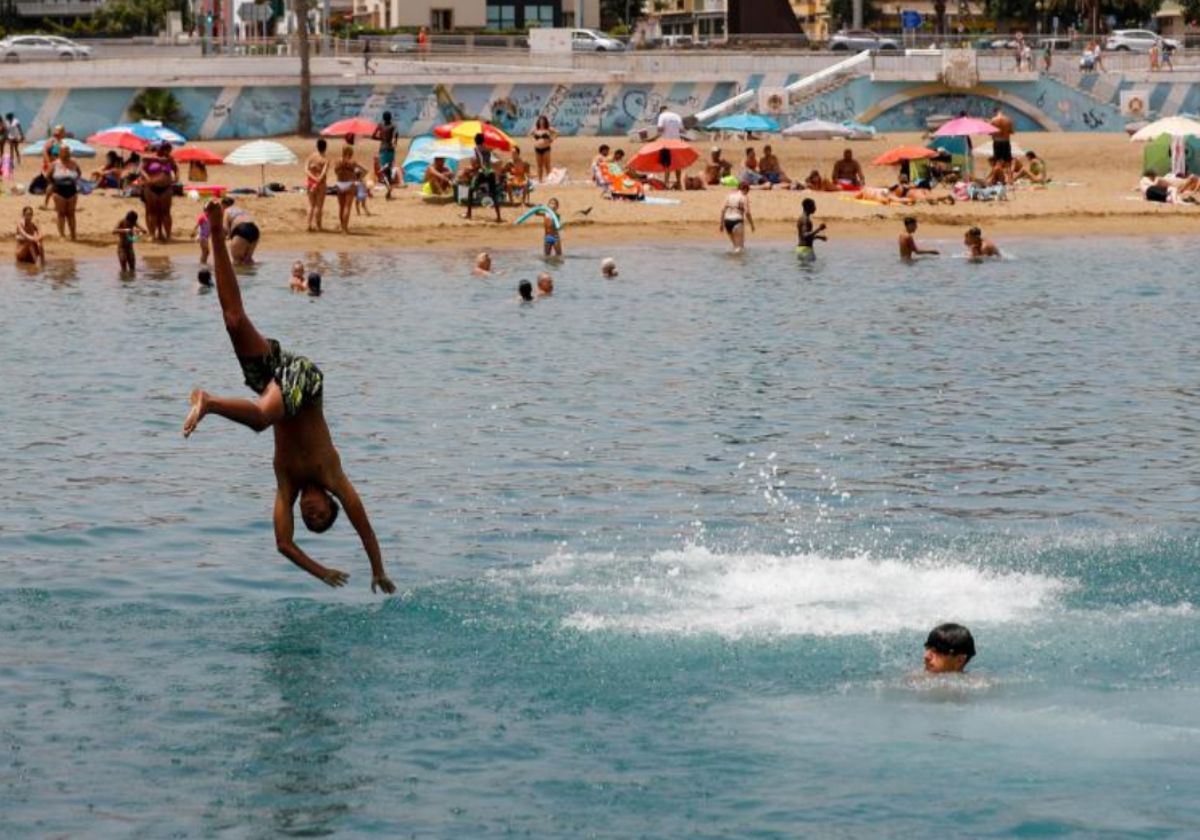 Un bañista se refresca de la ola de calor en la playa de Las Alcaravaneras, Gran Canaria