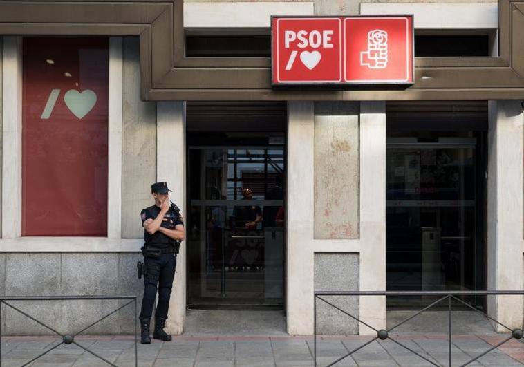 Un policía espera a la entrada de la sede del PSOE situada en la calle Ferraz