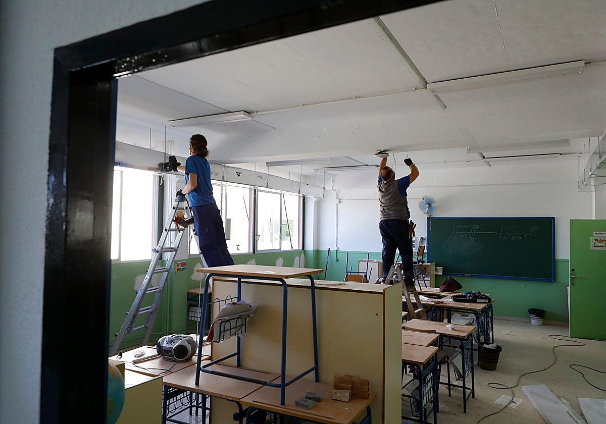 Dos operarios trabajan en un colegio de la capital