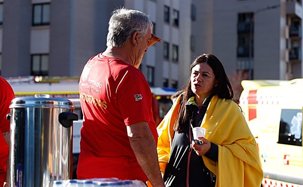 Una vecina afectada junto a personal de emergencias