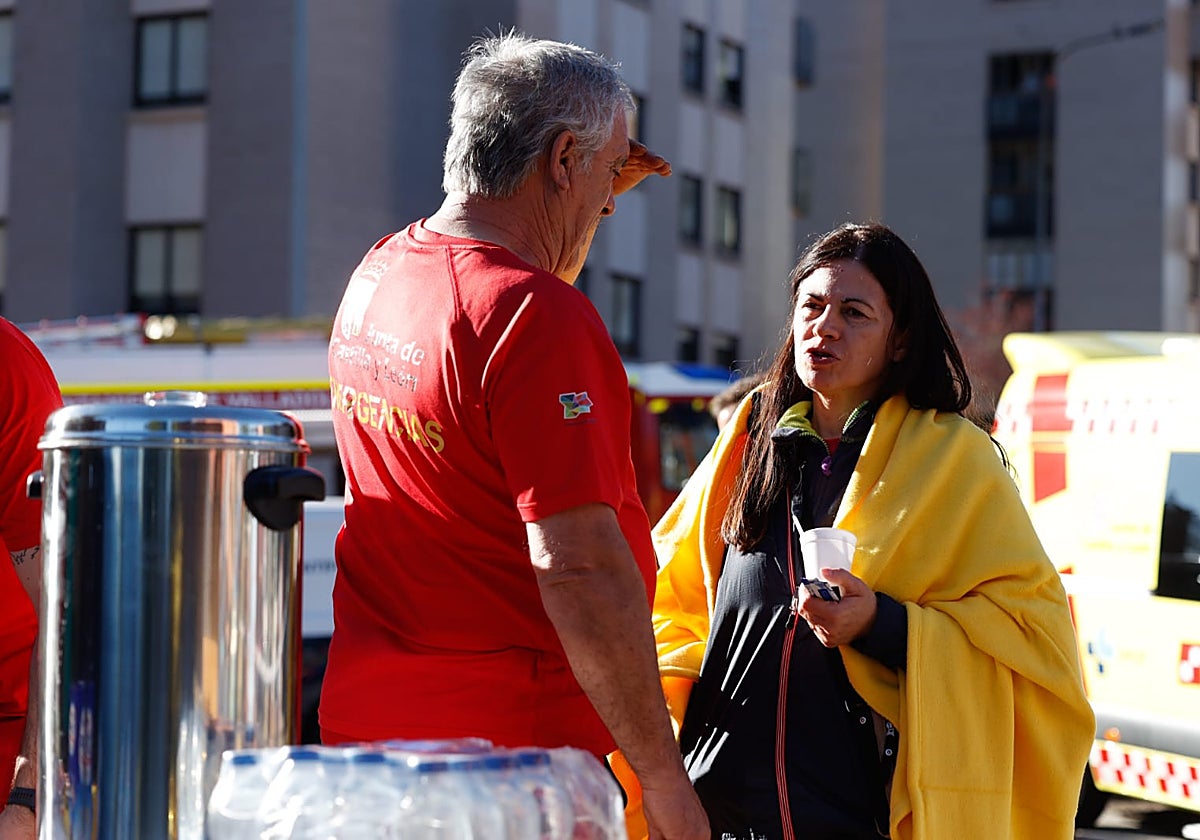 Un vecina junto a personal de emergencias en la calle Juna de Valladolid