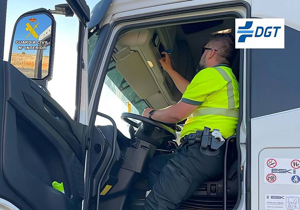 Imagen de un guardia civil revisando la tarjeta del tacógrafo en el camión incautado