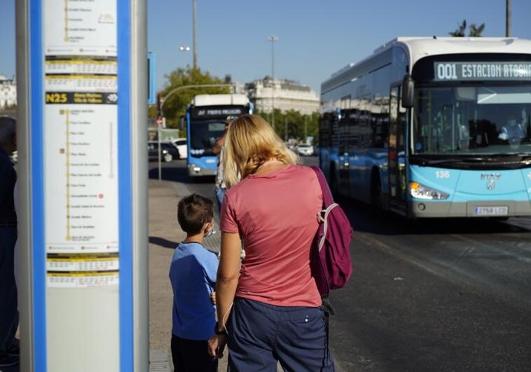 Madre e hijo esperan en una parada de la EMT