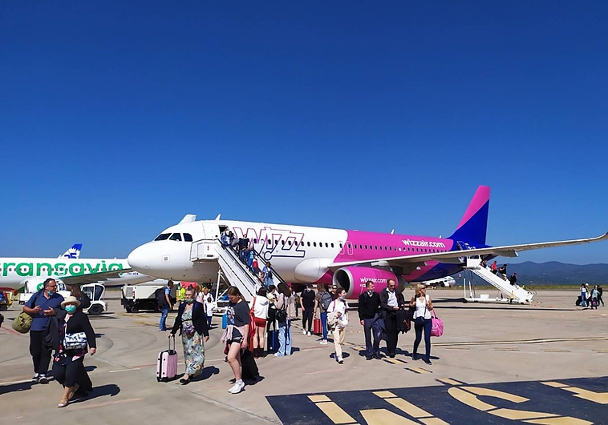 Imagen de pasajeros junto a un avión en la pista del aeropuerto de Castellón.