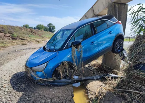 Imagen secundaria 1 - El auto quedó a merced de la inundación.  Un pilar lo salvó de llegar al río Tajo. 