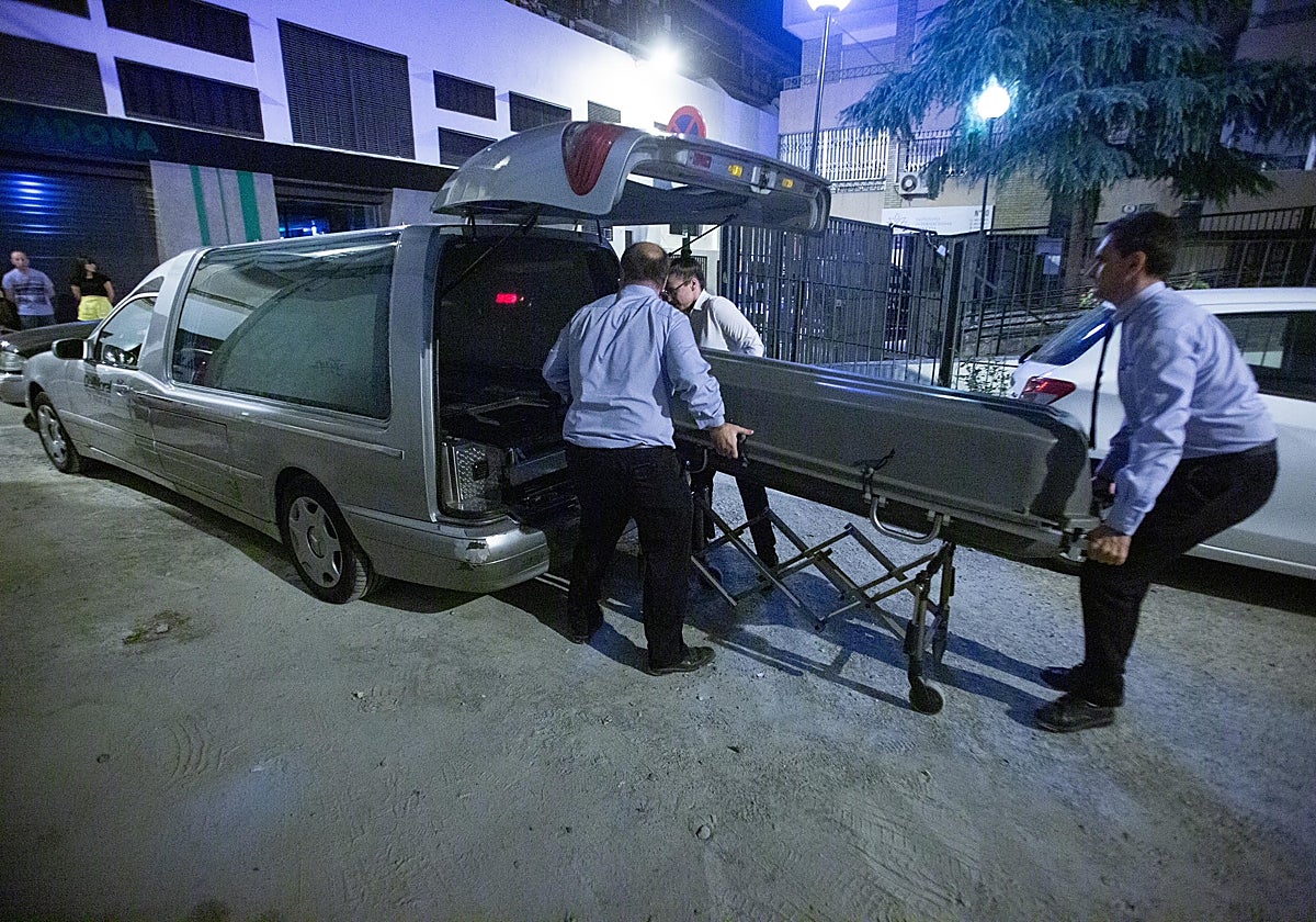 Trabajadores de una funeraria retiran en un ataúd el cuerpo de la mujer apuñalada por su pareja