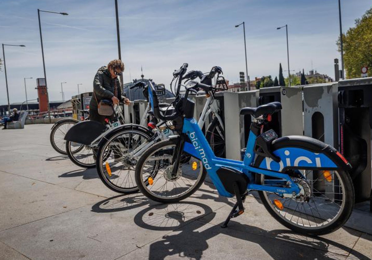 Una usuaria coge una bicicleta en una estación de Bicimad