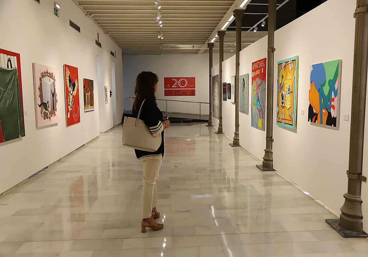 Una mujer mira varias obras de la exposición de la Fundación Gala