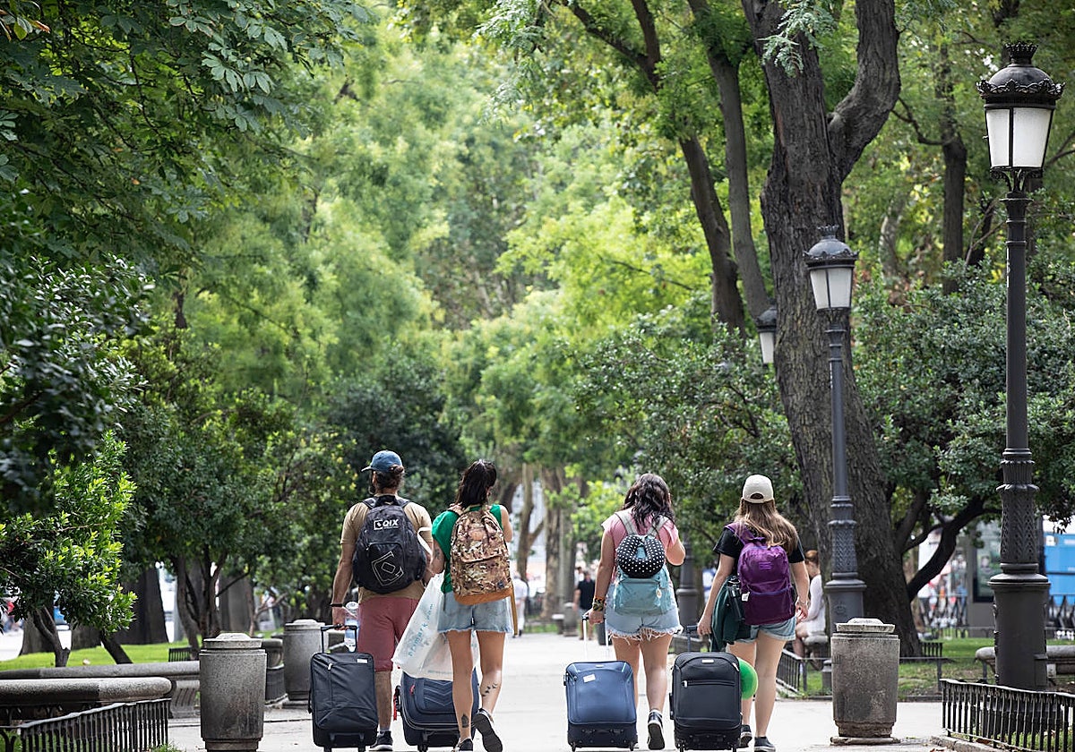 Un grupo de turistas cruza el paseo del Prado, el bulevar arbolado del Paisaje de la Luz