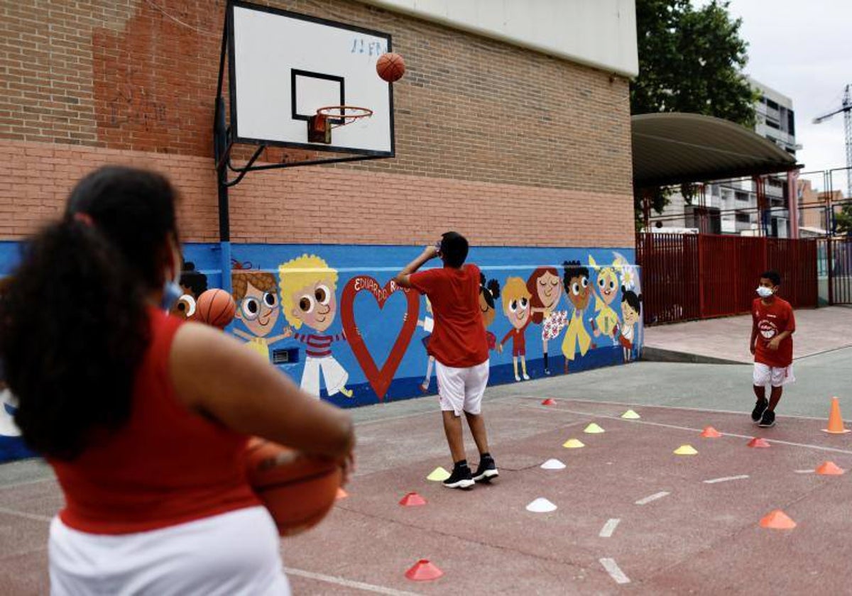 Un grupo de escolares juegan al baloncesto en un colegio, en una imagen de archivo