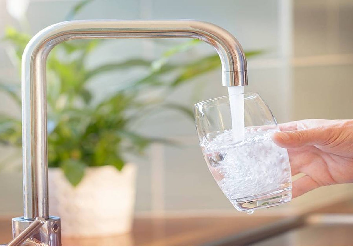 Un ciudadano echa agua del grifo en un vaso