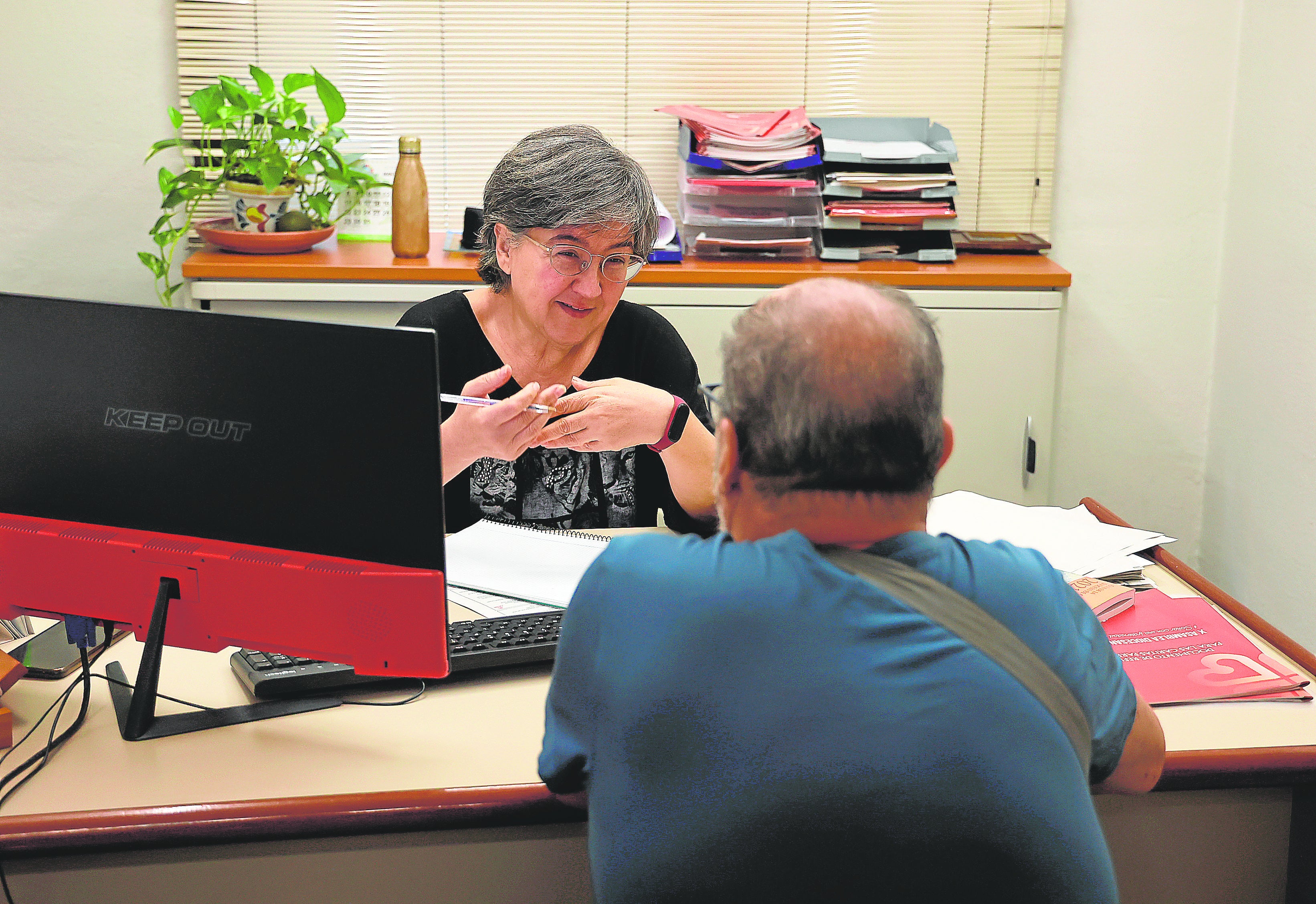 Una trabajadora de Cáritas atiende a una persona que pide ayuda