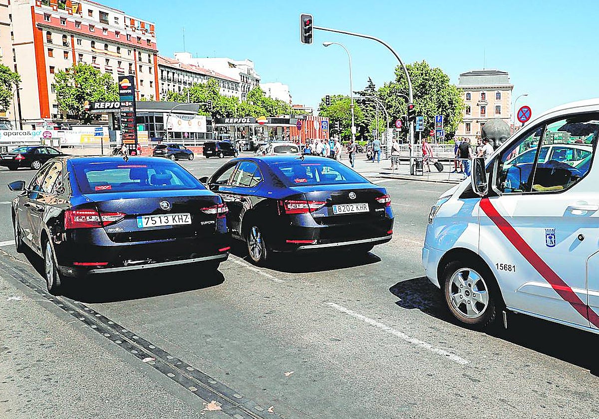 Varios VTC pasan por delante de un taxi en Atocha