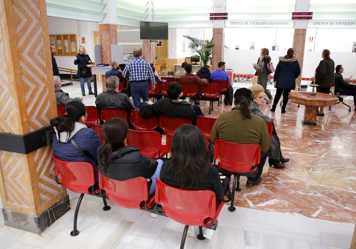 Varios ciudadanos esperan en las oficinas del Ayuntamiento de Córdoba en Gran Capitán