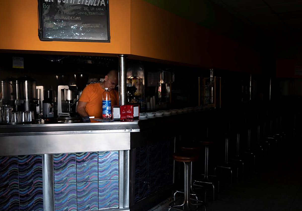 Un empleado de un bar de Tenerife intenta trabajar a oscuras durante el apagón de 2019