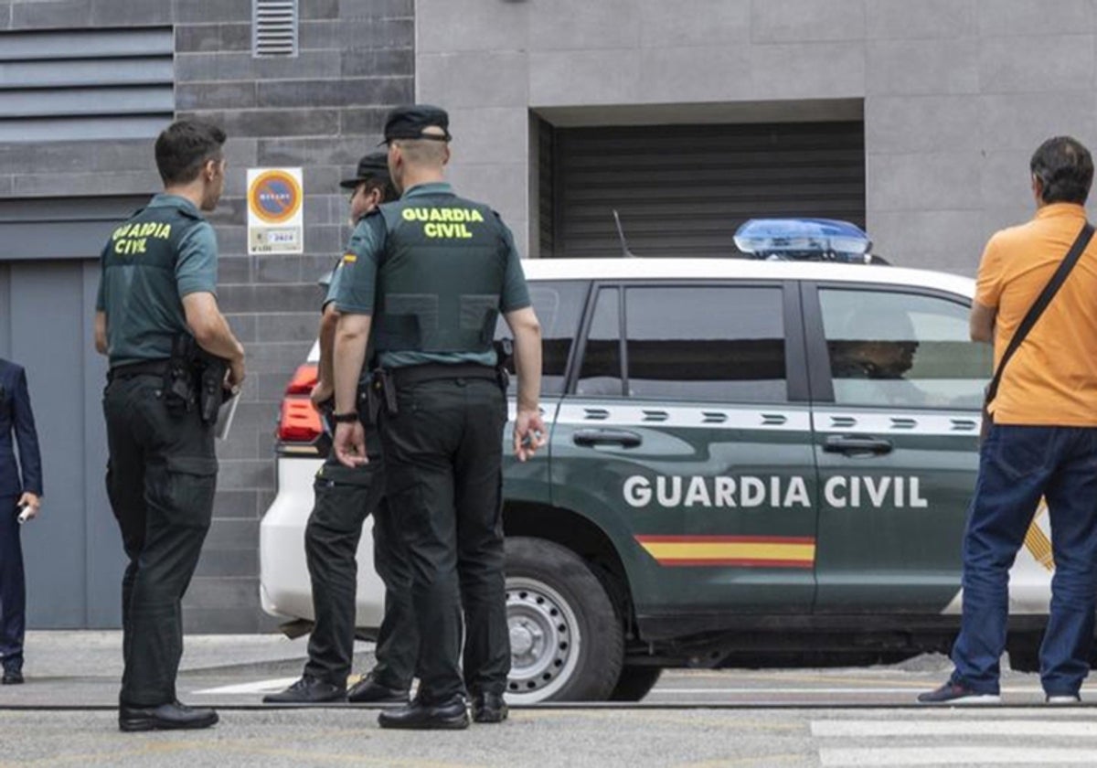 Imagen de archivo de tres agentes de la Guardia Civil junto a un coche patrulla