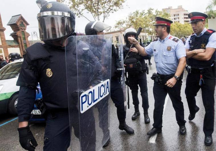 Agentes antidisturbios de la Policía Nacional y de los Mossos d'Esquadra durante el 1-O