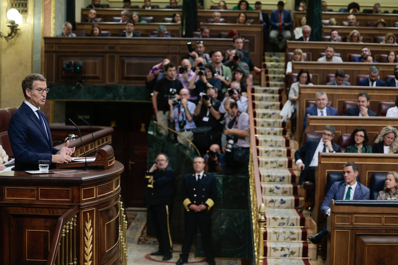 Pedro Sánchez escucha a Alberto Núñez Feijóo desde la primera fila durante el debate de investidura en el Congreso