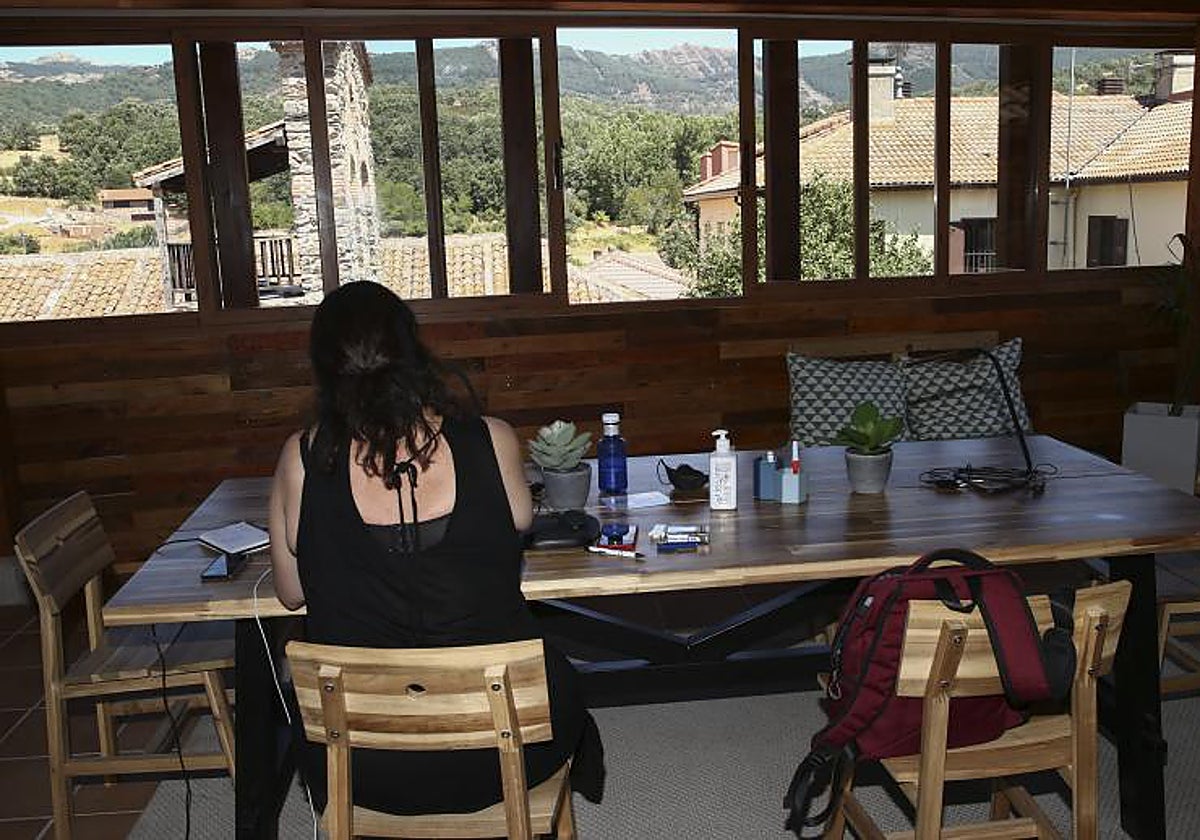 Una mujer teletrabaja en un coworking desde el municipio madrileño de Puebla de la Sierra