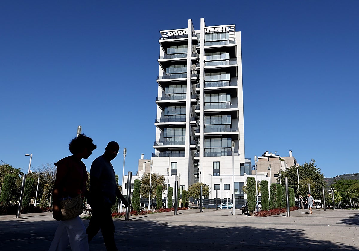 Dos personas pasean delante de la estela de la Torre del Agua, cuyas obras han acabado