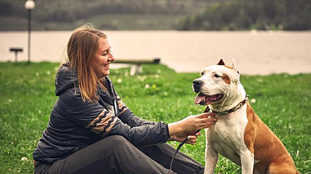 Una mujer junto a su perro en un parque