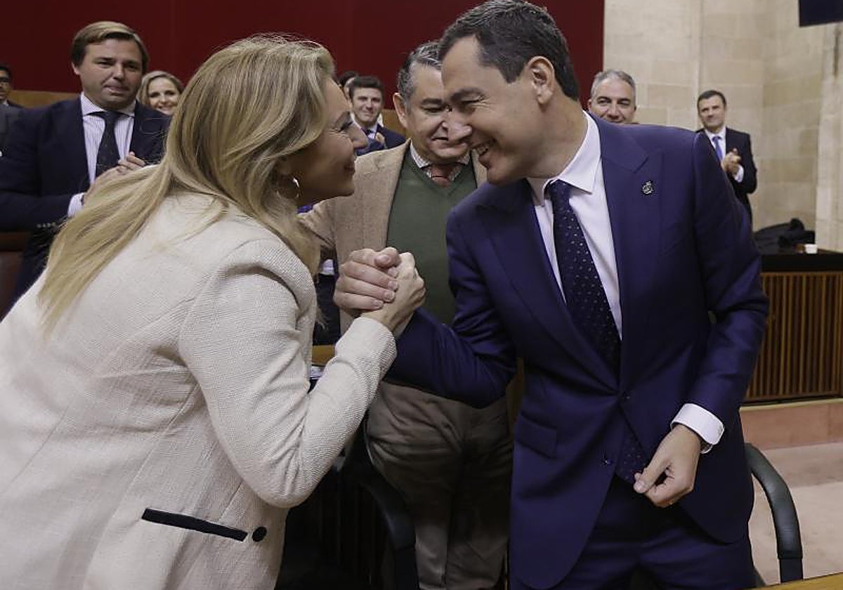 El presidente de la Junta de Andalucía, Juanma Moreno, felicita a la consejera de Hacienda, Carolina España, tras la aprobación de los presupuestos de la Junta en 2023 en el Parlamento
