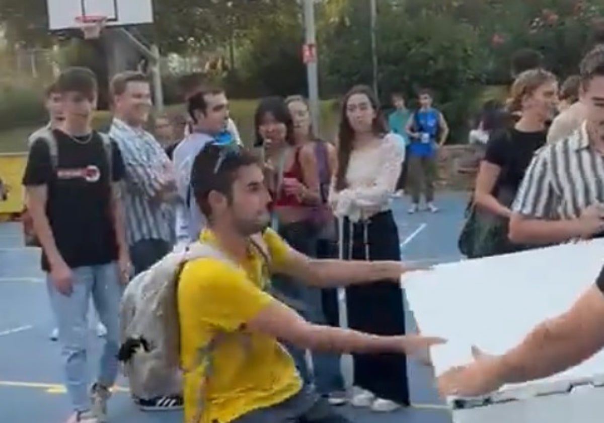 Un individuo trata de llevarse una mesa de los estudiantes constitucionalistas en la Universidad de Barcelona