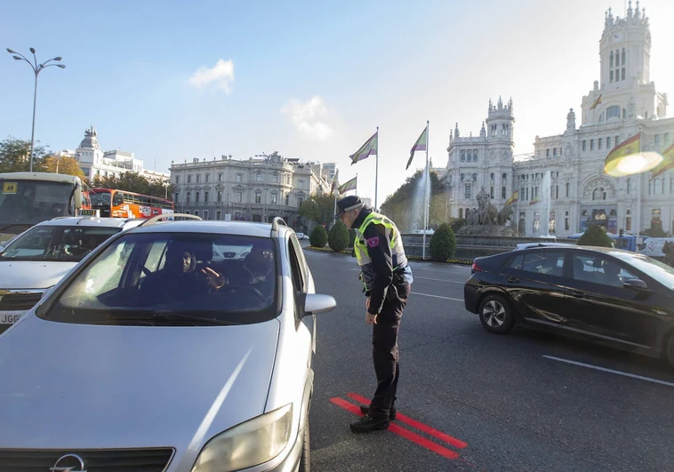 Un agente de movilidad regula el tráfico en la plaza de Cibeles