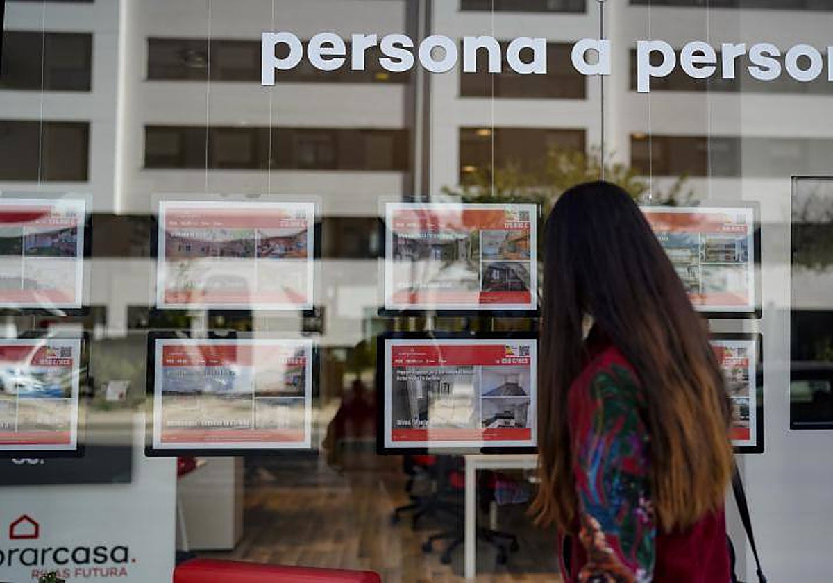 Joven mirando anuncios en una inmobiliaria