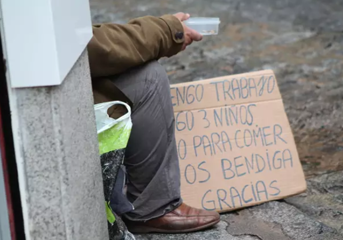 Persona pide dinero en la calle en foto de archivo