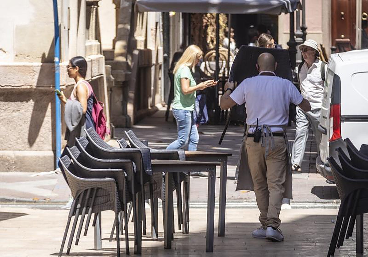 Imagen de archivo de un camarero recogiendo la terraza de un bar ajeno a esta noticia