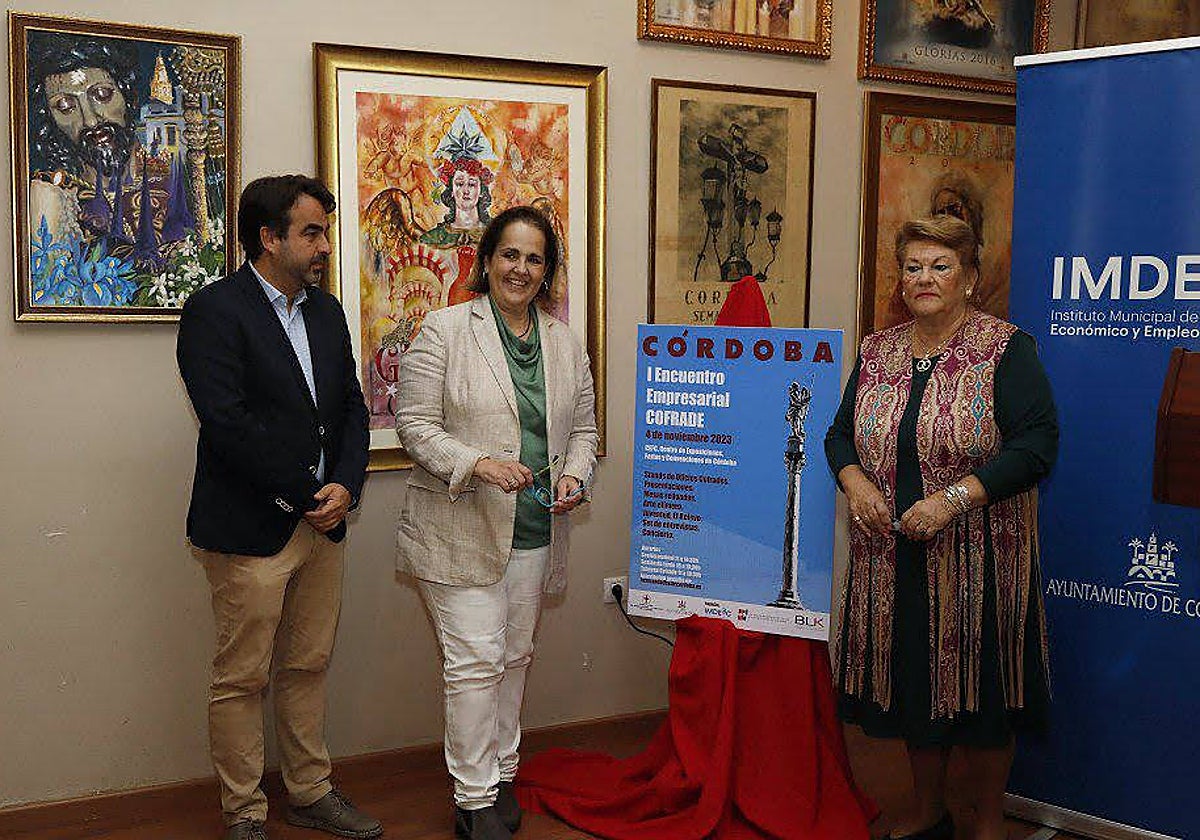 Antonio Márquez, Blanca Torrent y Olga Caballero, junto al cartel de encuentro, este lunes